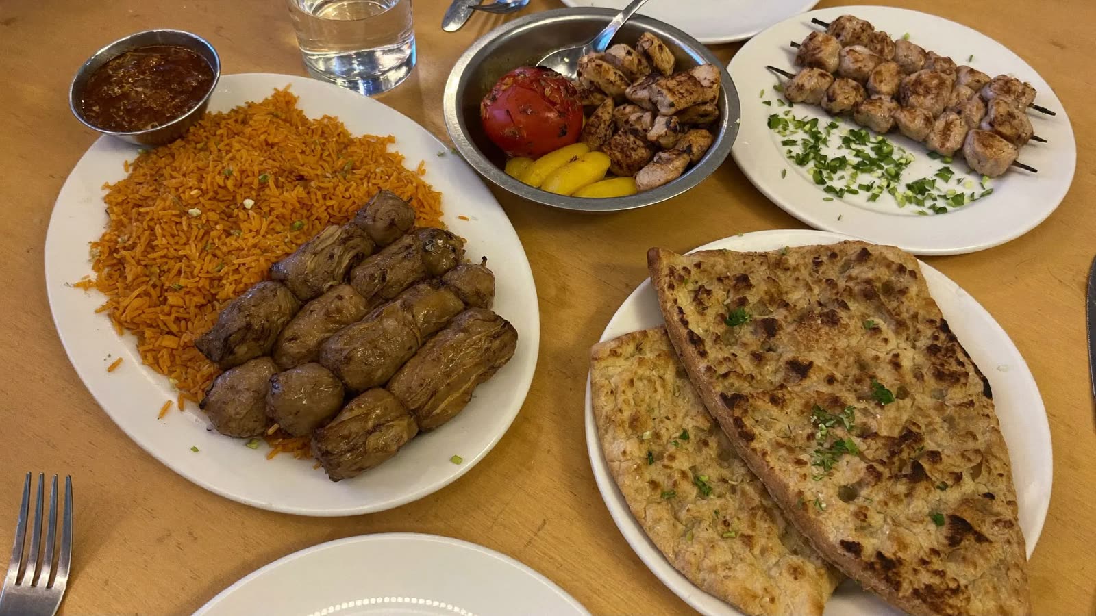 A Persian kabob plate with saffron rice, grilled tomato and koobideh skewers in North York
